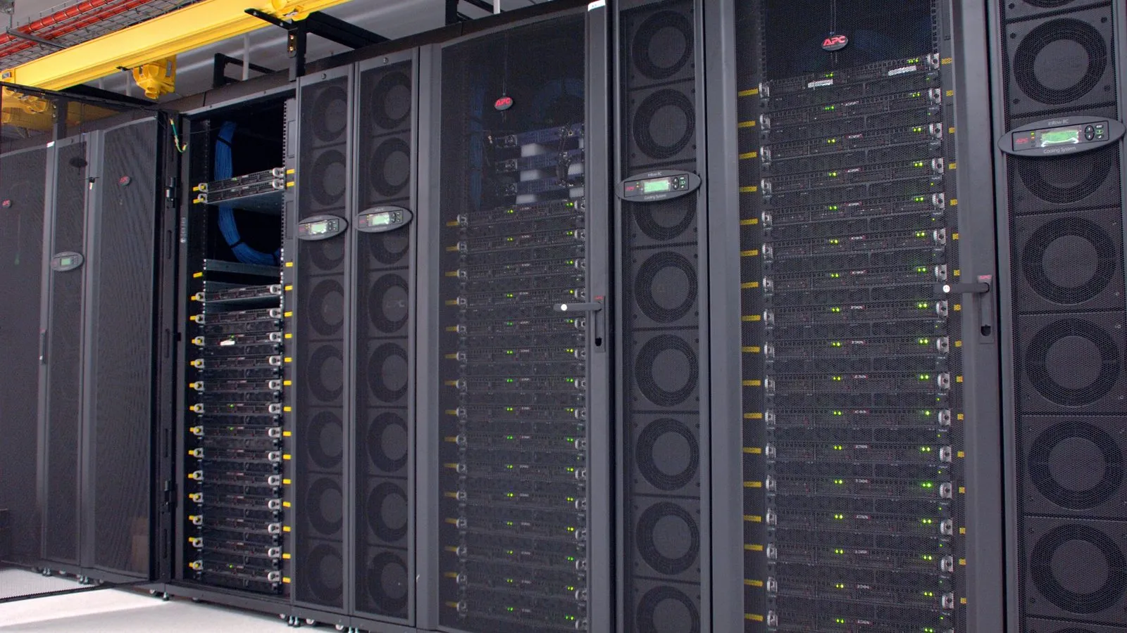 Reihen schwarzer Server-Racks in einem Rechenzentrum mit blinkenden Statusleuchten und großen Kühlpaneelen
